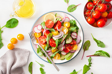 Canvas Print - healthy colorful vegan tomato salad with cucumber, radish, onion