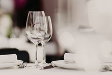 Served Restaurant Table With Cutlery And Wine Glasses Against Blurred Background. Banquet Table For Guests. Festive Event. Cozy Atmosphere. Catering Cafe Service