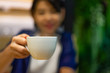 © dul_ny - Blurred image of Asian woman holding white cup