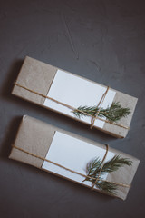 Christmas background with two gift boxes, fir-tree branches, decor. Top view with copy space, gray plastered background