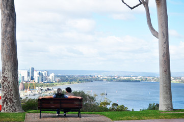 Australian old men and senior women travel and sit relax on bench in garden