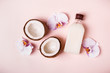 Coconut oil and halves of fresh coconut on a pink background. Hair care spa concept. Toned