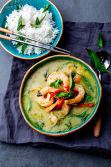 Wall Mural - THAI SHRIMPS GREEN CURRY. Thailand tradition green curry soup with shrimps prawns and coconut milk. Green Curry in blue plate on gray background.