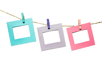 Wall Mural - Colorful funny picture frames hanging on a rope with clothespins twine isolated on white background