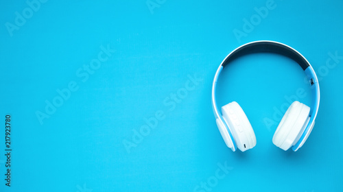 White headphones on a blue background. Tableau sur Toile