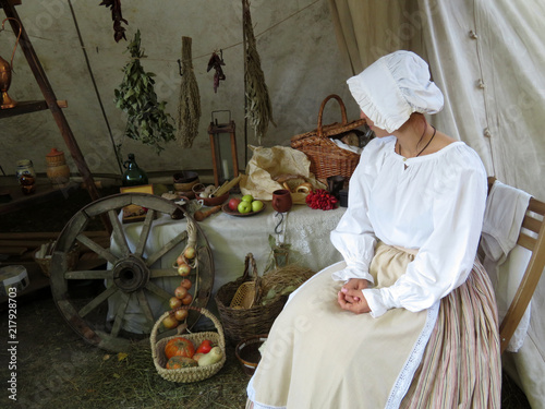 Woman in ancient dress sitting on the background of a street shop with the foodstuffs Tableau sur Toile