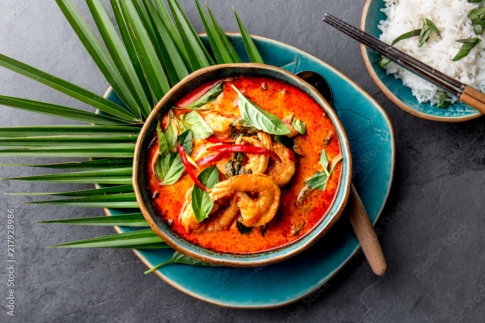 THAI SHRIMPS RED CURRY. Thailand Thai tradition red curry soup with shrimps prawns and coconut milk. Panaeng Curry in blue plate on gray background - obrazy, fototapety, plakaty 
