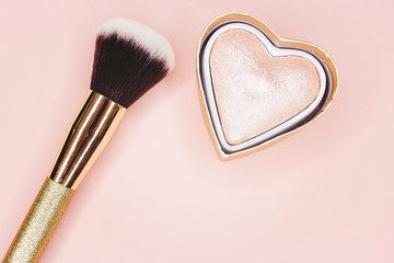 Glitter and makeup brush on a pink background