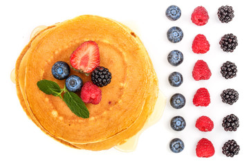 Wall Mural - Pancakes stack with different berries isolated on white background. Top view. Flat lay