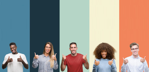 Sticker - Group of people over vintage colors background success sign doing positive gesture with hand, thumbs up smiling and happy. Looking at the camera with cheerful expression, winner gesture.