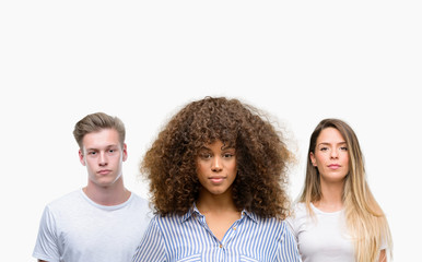 Group of young people over white background with a confident expression on smart face thinking serious