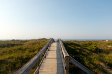 Long Wooden Boardwalk Through The Green Dune Grass To The Atlantic Ocean, Sunset Beach, North Carolina