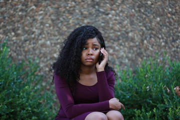 Wall Mural - Unhappy black woman speaking on smartphone