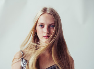 Blonde long hair woman girl in silver dress over white background