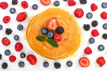 Wall Mural - Pancakes stack with different berries isolated on white background. Top view. Flat lay