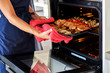 © eskstock - Beautiful young woman preparing meat in oven in the domestic kitchen.
