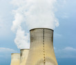 © olrat - Three natural draft cooling towers of a nuclear power plant releasing clouds of water vapor against a dark stormy sky.