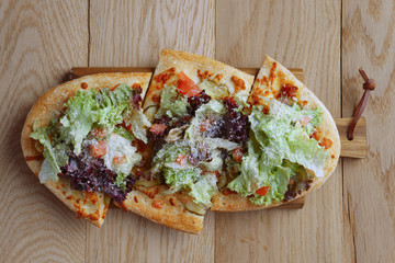 Freshly baked focaccia with salad leaves, tomato and cheese