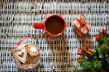 Wall Mural - Rustic background with red cup of coffee, gingerbread and spruce branches with red berries. Breakfast at winter Christmas morning. Top view.