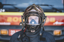 Firefighter Poses With Helmet Looking At Camera.