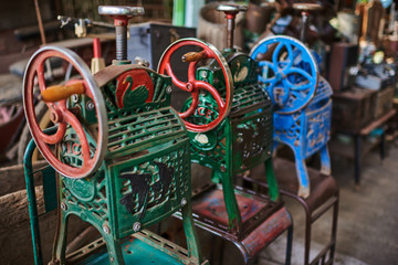 Hand ice shaving machine. Various vintage objects for sale at a indoor flea market. View of a display full of interesting old things for sale. Many groups of vintage assorted second-hand objects.