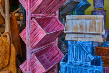 View of a colorful furniture of drawers. Shabby vintage style interior, furniture from rustic whitened wood. Wooden drawers made of natural wood with handles and shelves of untreated wood for sale.