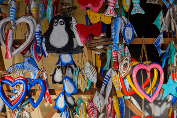 Wall Mural - Souvenir background. Travel and tourism concept. Hanging handicraft decoration wooden carved toys. Art and craft market. Display of handicraft decoration in the open market. Selective focus