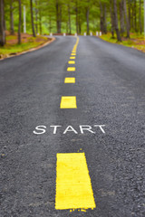 Words of start with yellow line marking on road surface in the park, transportation concept and business idea