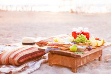 Picnic On The Beach At Sunset In The Style Of Boho. Concept Outdoors Evening Healthy Dinnner With Fruit And Juice