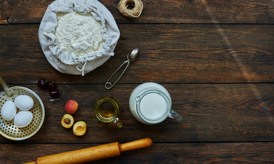 Baking background with copy space. Cooking ingredients for dough and pastry, eggs, flour and butter on dark rustic wood. Homemade baking theme. Top view, mockup for menu, recipe for culinary classes.