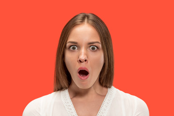 Wall Mural - Wow. Beautiful female half-length front portrait isolated on red studio backgroud. Young emotional surprised woman standing with open mouth. Human emotions, facial expression concept.