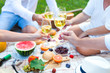 © yatcenko - Summer Picnic Basket on the Green Grass. Food and drink concept. Friends Party time