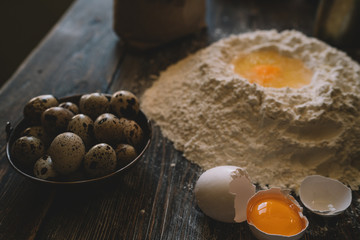 Food, cooking and baking concept. Dough on a rustic wooden background with dusting of flour. Raw dough for pizza, ingredients and kitchen accessories on dark wooden background.