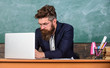 © be free - Writing school report. School teacher typing report laptop. Teacher sit at desk with laptop. Back to school concept. Teacher bearded hipster with eyeglasses sit in classroom chalkboard background
