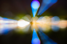 Abstract Bokeh Of Green, Yellow, Red, Blue On Street Lights Black Background. Night Life And Reflect On The Water. Zoom And Digital Line Concept.