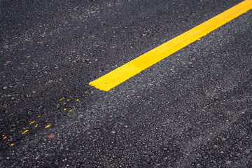 Asphalt road surface with yellow line