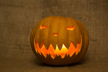 Halloween symbol jack-o-lantern. Scary carved pumpkin with burning candles. Copy space.