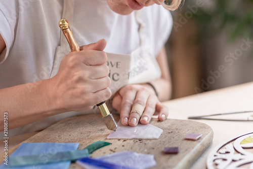 Fotografía Artist cutting sheets of stained glass into small mosaic squares