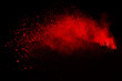 Abstract of red powder explosion on black background. Red powder splatted isolate. Colored cloud. Colored dust explode. Paint Holi.