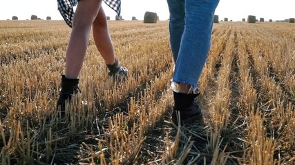 Wall Mural - Cropped view of Young lovely hipster couple walking together on field