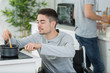 © auremar - disabled young man in wheelchair cooking in the kitchen
