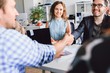 © pantovich - Business people shake hands sitting at the white table