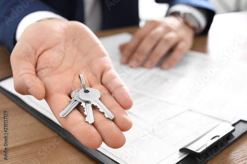 Cuadros en Lienzo Real estate agent with keys at table in office, closeup