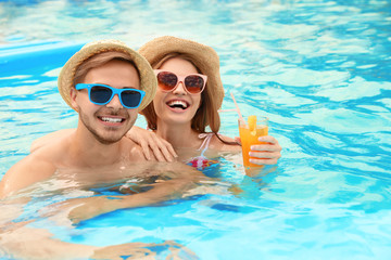 Canvas Print - Young couple in pool on sunny day