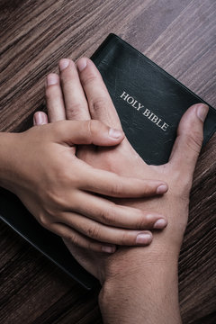 Child and Man Hands On The Bible