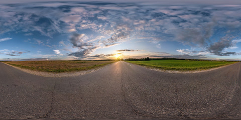 Wall Mural - full seamless spherical panorama 360 degrees angle view on asphalt road among fields in summer evening sunset with awesome clouds in equirectangular projection, skybox VR AR virtual reality content