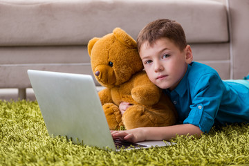 Little boy surfing internet on laptop