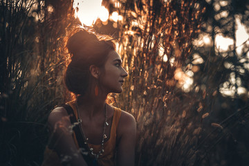 Wall Mural - beautiful young woman on a field at sunset