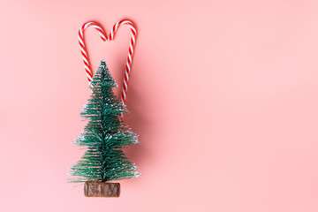 Poster - Christmas tree with candy cane hanging on pastel pink wall.Holiday festive celebration greeting card.