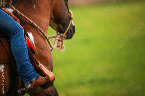 Fotografía Horse, western pony, close-up of the rider's leg in the stirrup with spurs!